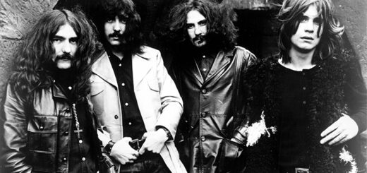 Schwarz-weiß-Fotografie der Originalbesetzung von Black Sabbath aus dem Jahr 1970 mit Geezer Butler, Tony Iommi, Bill Ward und Ozzy Osbourne, die nebeneinander in Lederjacken vor einer Wand posieren – Symbolbild für den Ursprung des Heavy Metal.